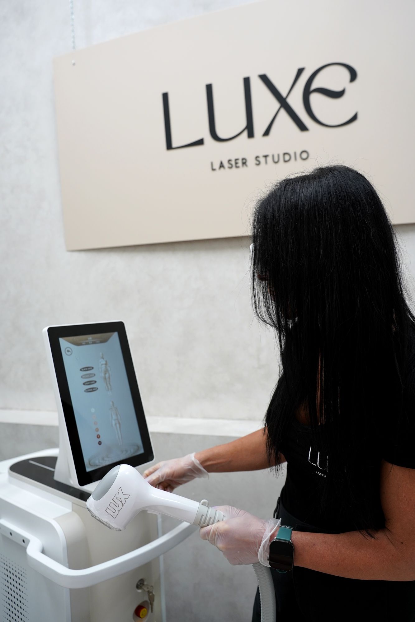 Sharon setting up treatment on the Skyn Lux touchscreen under the Luxe sign