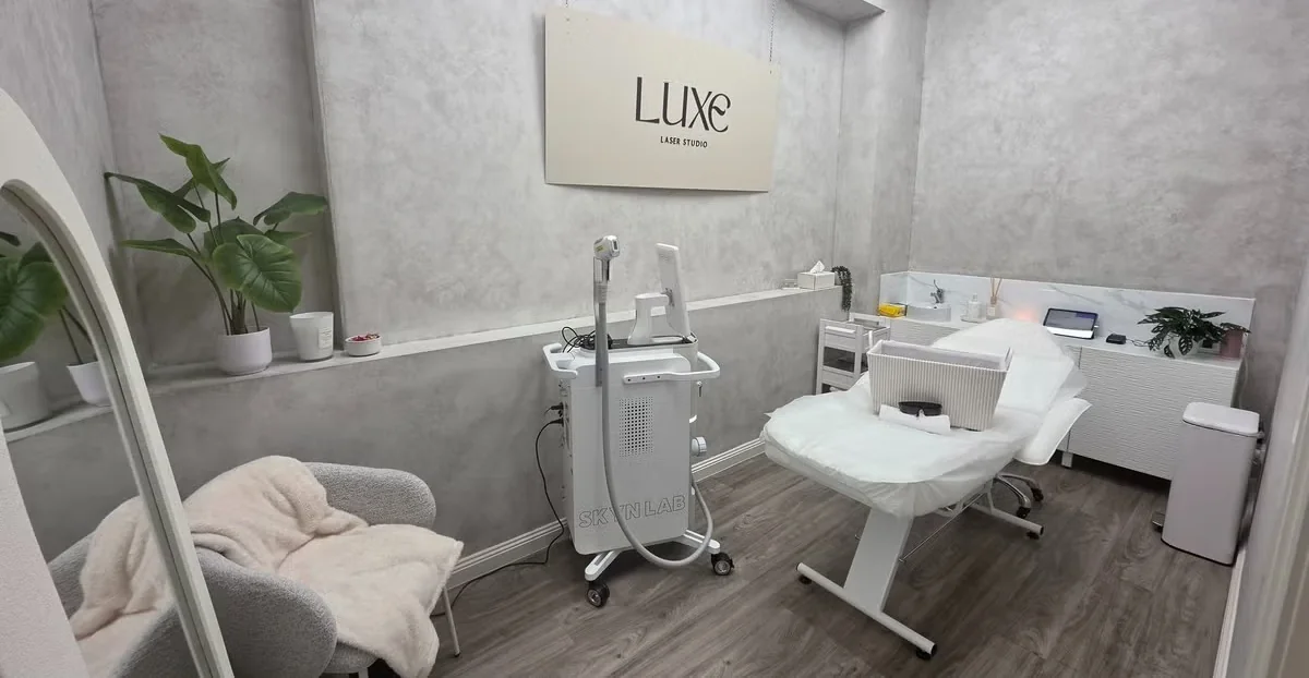 Luxe Laser Studio treatment room with the Luxe sign on the wall, the Skyn Lux laser and treatment bed