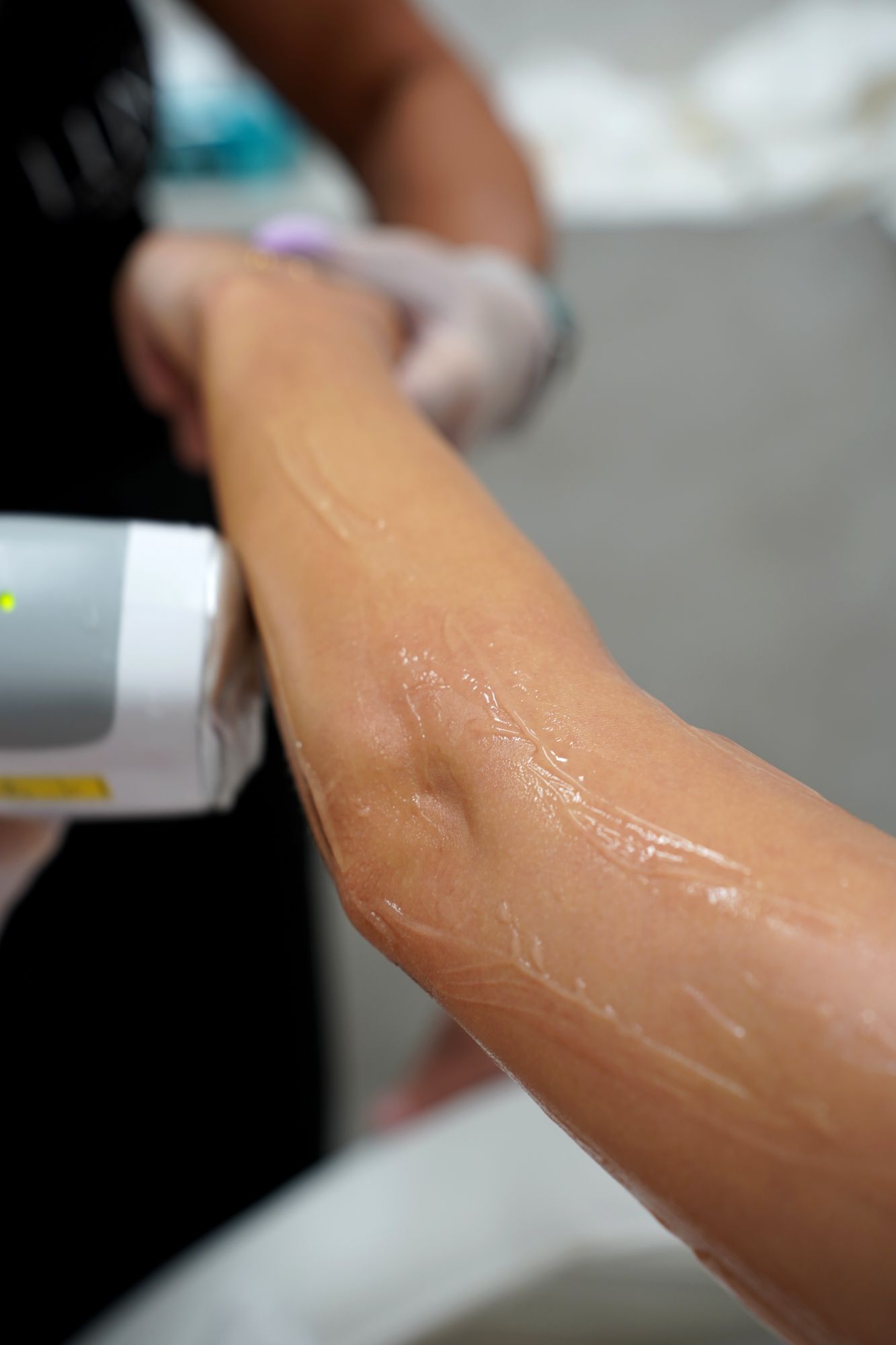 Sharon holding a client's leg steady during treatment