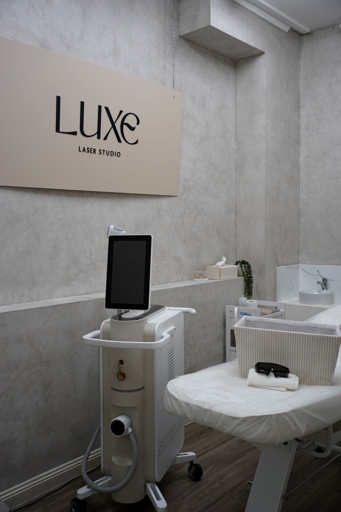 The Luxe Laser Studio room with the Luxe sign, Skyn Lux laser and treatment bed